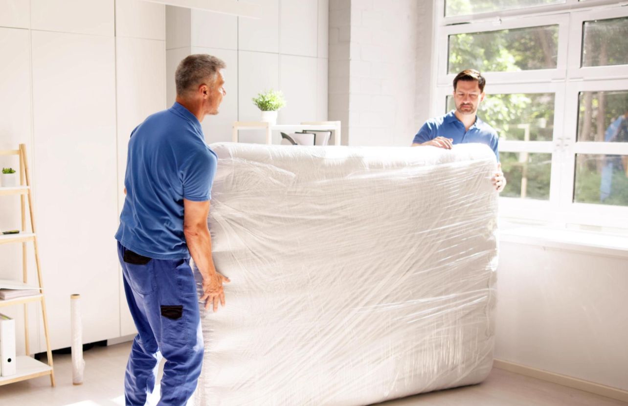 Umzugshelfer tragen eingewickeltes Sofa